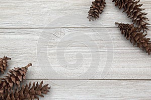 Pinecones laying on a wooden backdrop