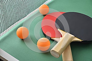 Ping pong paddles and balls on green game table