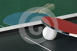 Ping Pong Paddles on Table with Net, one out of focus