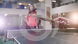 Ping pong playing. Young woman beats a ball with a little racket for table tennis
