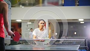 Ping pong playing. Young woman playing table tennis with another woman