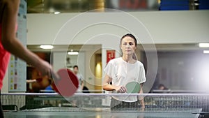 Ping pong playing. Young woman playing table tennis. Her opposer fails and she throws up her hands