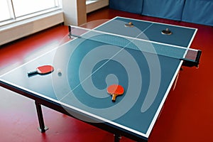 Ping pong rackets on game table with net, nobody