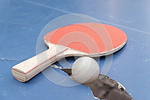 pingpong ball and racket on a damaged table at horizontal composition