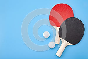 Pingpong lesson and winning competitive challenge concept with red and black table tennis or ping pong paddle isolated on blue