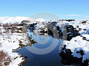 Pingvellir National Park, Iceland - clear natural blue water, reflection, snow.