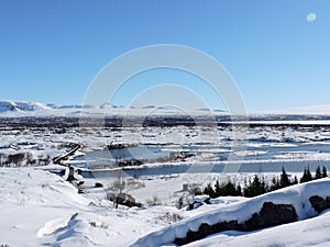 Pingvellir National Park Landscape Iceland. Water, mountains, snow and road.