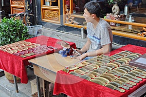 Young Chinese man making wooden combs