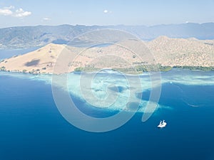 Pinisi Ship, Coral Reef, and Island in Indonesia