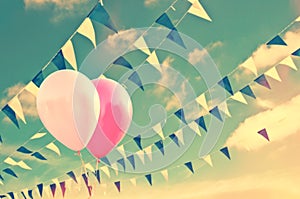 Pink air balloons on sky background with blue and white garlands, summer party concept
