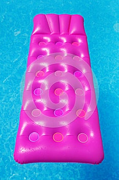 Pink air mattress in swimming pool. Holiday background.