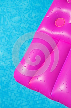 Pink air mattress in swimming pool. Holiday background.