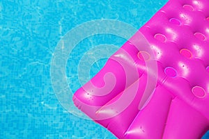 Pink air mattress in swimming pool. Holiday background.