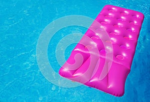 Pink air mattress in swimming pool. Holiday background.