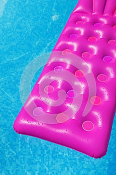 Pink air mattress in swimming pool. Holiday background.