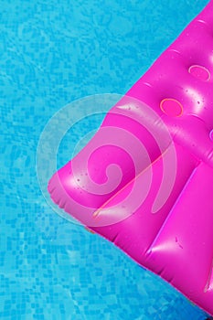 Pink air mattress in swimming pool. Holiday background.