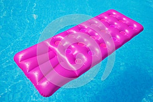 Pink air mattress on a swimming pool tropical