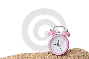 Pink alarm clock on the beach