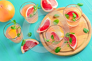 Pink alcoholic cocktail with grapefruit, ice and min