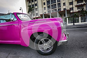 pink American classic cars are often used as taxis for tourists in Havana