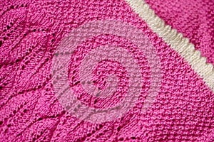 Pink baby blanket with a white border, hand-knitted