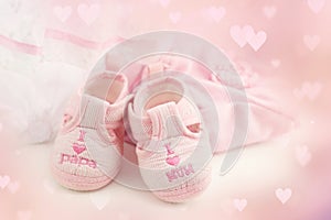 Pink baby booties on a bright pink background. Baby Clothing
