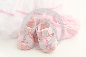 Pink baby booties on a bright pink background. Baby Clothing