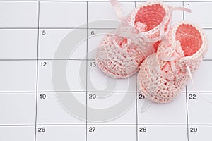 Pink baby booties on a calendar