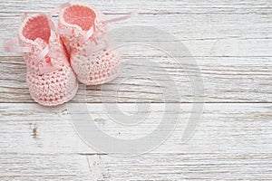 Pink baby booties on weathered wood photo