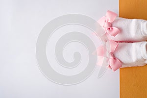 Pink baby boots on white and yellow background. little girl socks. place for text. copy space