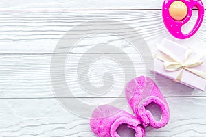 Pink baby`s bootees on wooden background