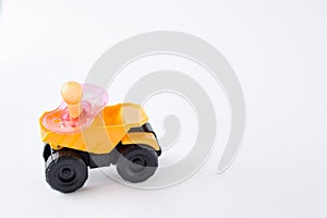 pink baby`s pacifier nipple on yellow car isolated on white background. place for text.copy space