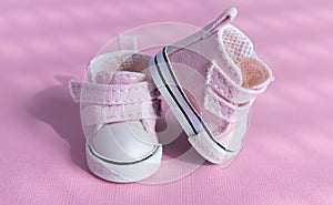 Pink baby shoes on a gentle pink background. The concept of the first steps, birthday, expectation, pregnancy, motherhood,