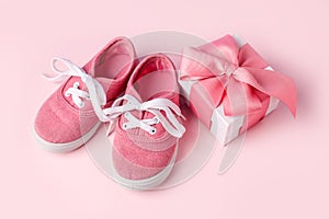 Pink baby shoes and gift present box, concept of first steps, birthday, baby shower, expectation, pregnancy, maternity, motherhood