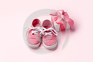 Pink baby shoes and gift present box, concept of first steps, birthday, baby shower, expectation, pregnancy, maternity, motherhood