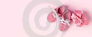 Pink baby shoes and gift present box, concept of first steps, birthday, expectation, pregnancy, maternity, motherhood, parenthood