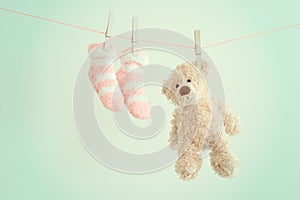 Pink baby socks and teddy bear with copy space. Children background