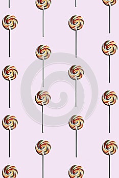 pink background of candy lollipop sweet with stick, delicious and fun food with colorful sugar. wallpaper, top view