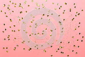 Pink background with gold sequins and shining paillettes. Festive backdrop for your projects. Top view, copy space