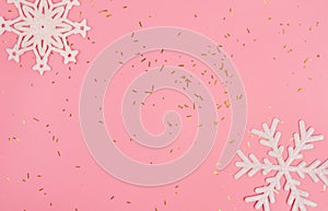 Pink background with snowflakes and golden confetti with copy space