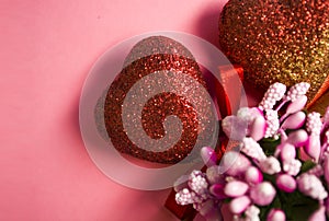 Pink background. St. Valentine`s Day. Red hearts in spangles with bows. Love. Bouquet of flowers. The place for an inscription.