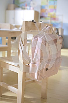 Pink backpack and wooden chair