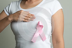 Pink badge ribbon on woman chest to support breast cancer cause. breast cancer awareness concept