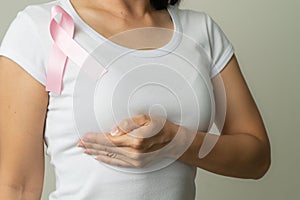 Pink badge ribbon on woman chest to support breast cancer cause. breast cancer awareness concept