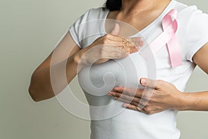 Pink badge ribbon on woman chest to support breast cancer cause. breast cancer awareness concept