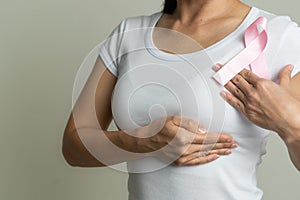 Pink badge ribbon on woman chest to support breast cancer cause. breast cancer awareness concept