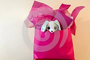 Pink bag birthday present with stuffed puppy inside