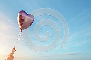 Pink balloon in the shape of a heart against the blue sky Space for text Holiday card, Happy Valentine`s day concept Love in air