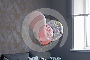 Pink balloons in the interior of a dark gray room of a teenage girl