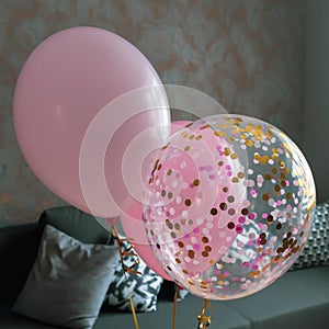 Pink balloons in the interior of a dark gray room of a teenage girl